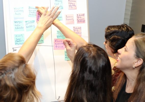 women pointing to whiteboard 